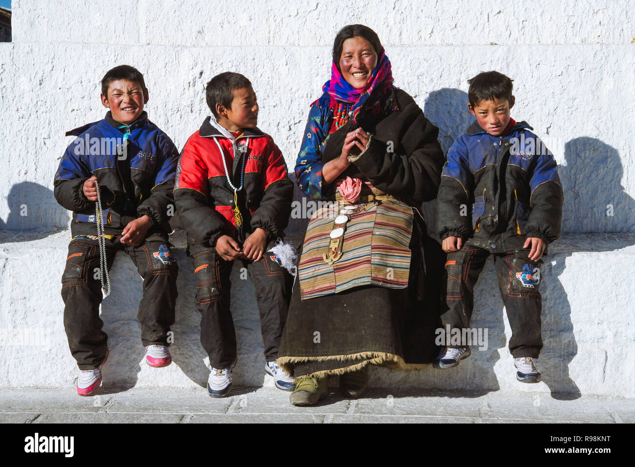 Lhasa, Tibet autonomen Region, China: Eine tibetische Pilger Familie draußen sitzen eine buddhistische Stupa. Stockfoto