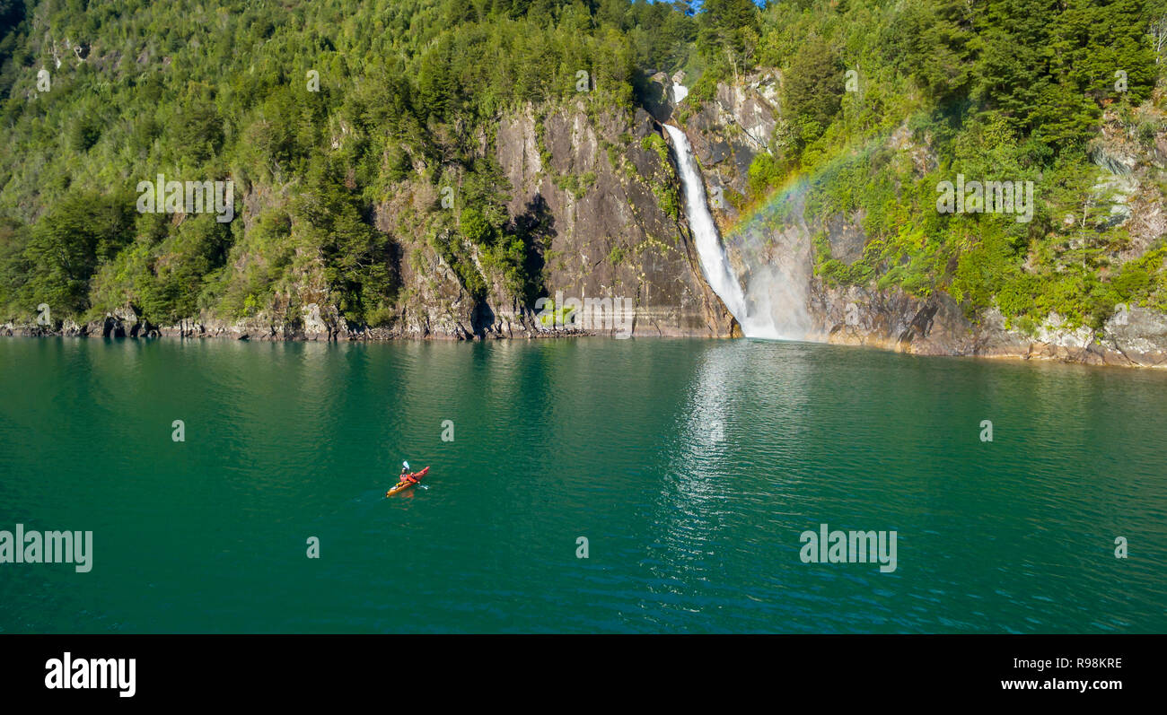 Mann in Kajak paddeln in Richtung Wasserfall der Velo de La Novia, im See aus Tagua Tagua Stockfoto