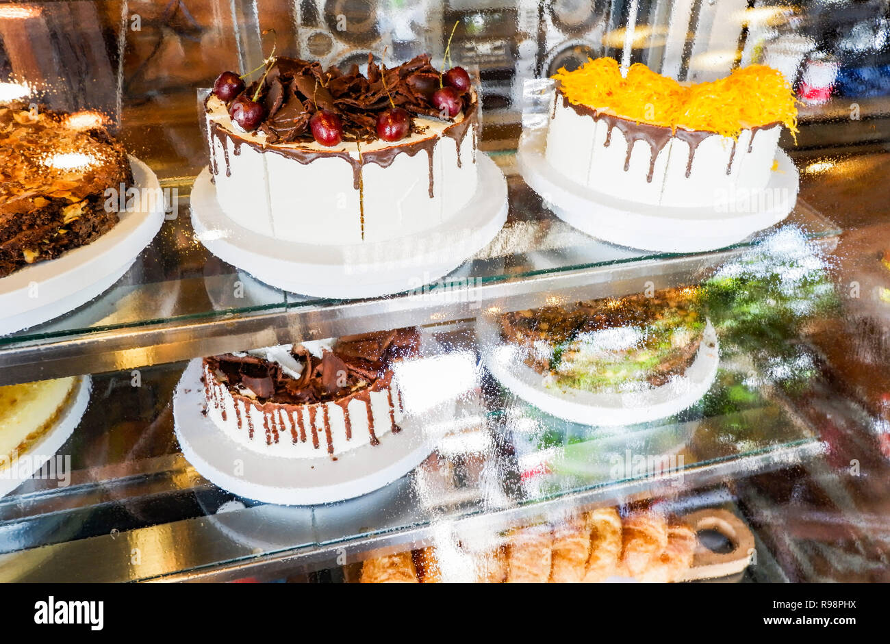 Kuchen im Schaufenster/Fach Kuchen im Glas Anzeige bei Store Bäckerei Konditorei - Showcase mit Süßigkeiten Schokolade Kuchen selektiven Fokus Stockfoto
