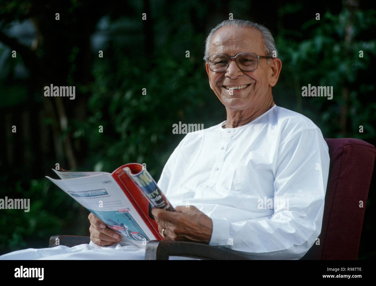 Alter Mann im Garten lesen Magazin sitzen - HERR #318 Stockfoto