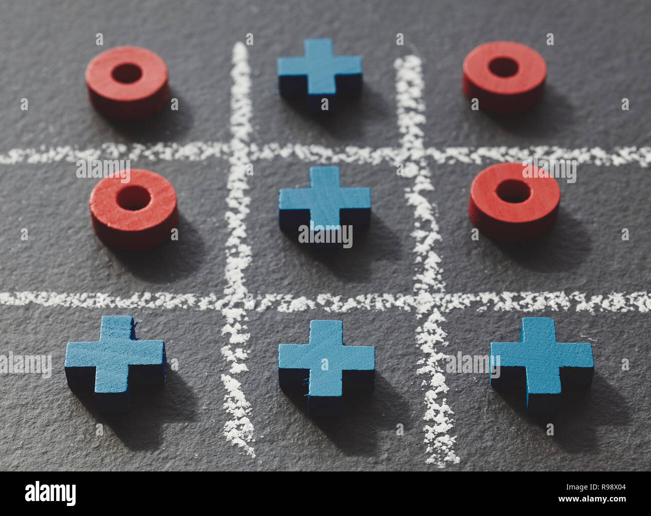 Tic Tac Toe Spiel (Nullen und Kreuze) auf dunklem Schiefer Hintergrund, selektiver Fokus, retro Farbe Tonen angewendet. Stockfoto