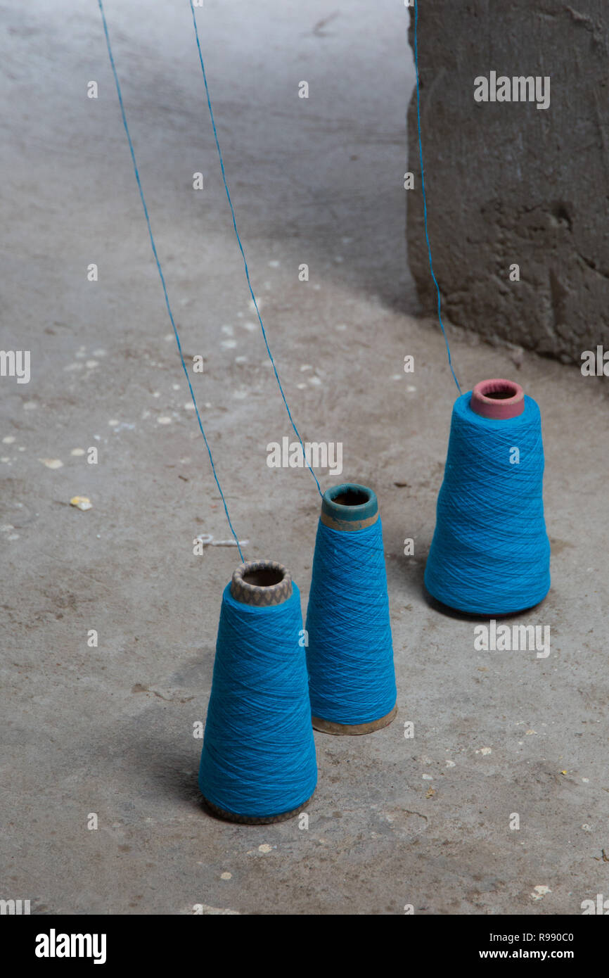 Kegel von Faden aufgereiht auf dem Boden des Weber studio, Ecuador, 2018 Stockfoto