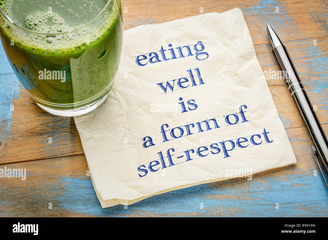 Gut essen ist eine Form der Selbstachtung - Handschrift auf eine Serviette mit einem Glas frisch, grün, Gemüsesaft Stockfoto