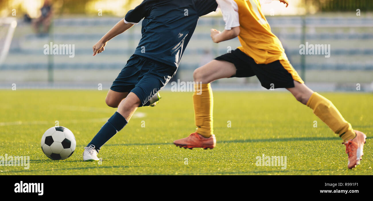 Fußball-Fußball-Spieler konkurrieren im Stadion. Zwei Fußballer laufen und kicken Fußball. Fußballspiel Hintergrund Stockfoto