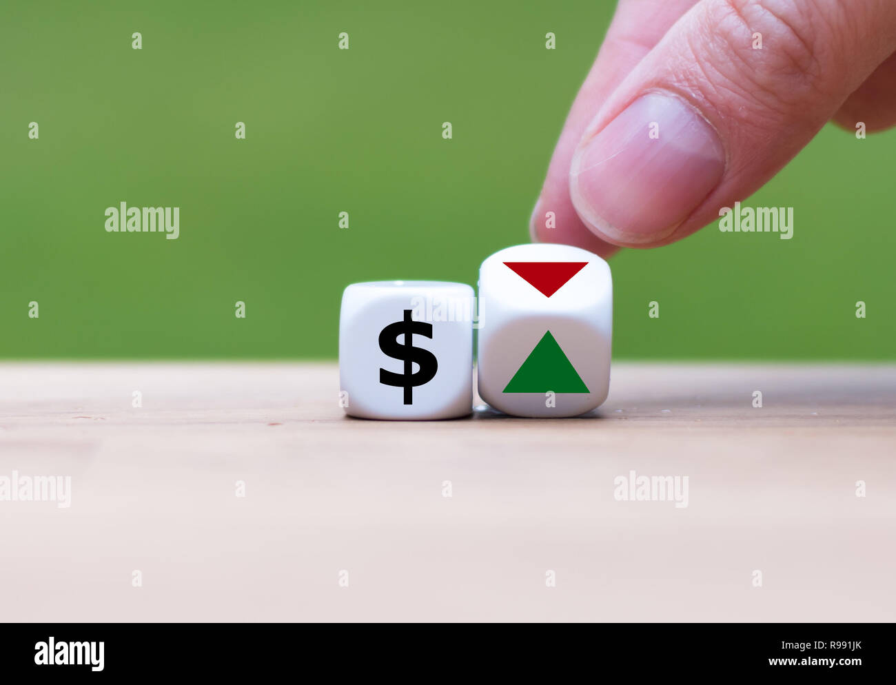 Hand dreht einen Würfel und verändert die Richtung, in die sich ein Pfeil symbolisiert, dass der Wert des US-Dollars wird (oder umgekehrt) Stockfoto