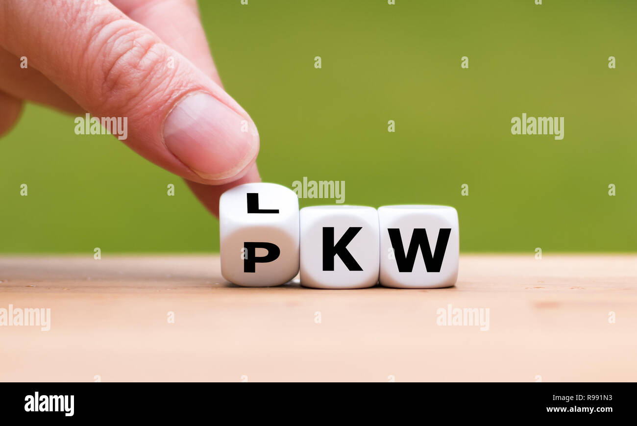 Hand dreht einen Würfel und Änderungen der deutsche Ausdruck "PKW" zu "LKW" für Pkw und Lkw steht Stockfoto
