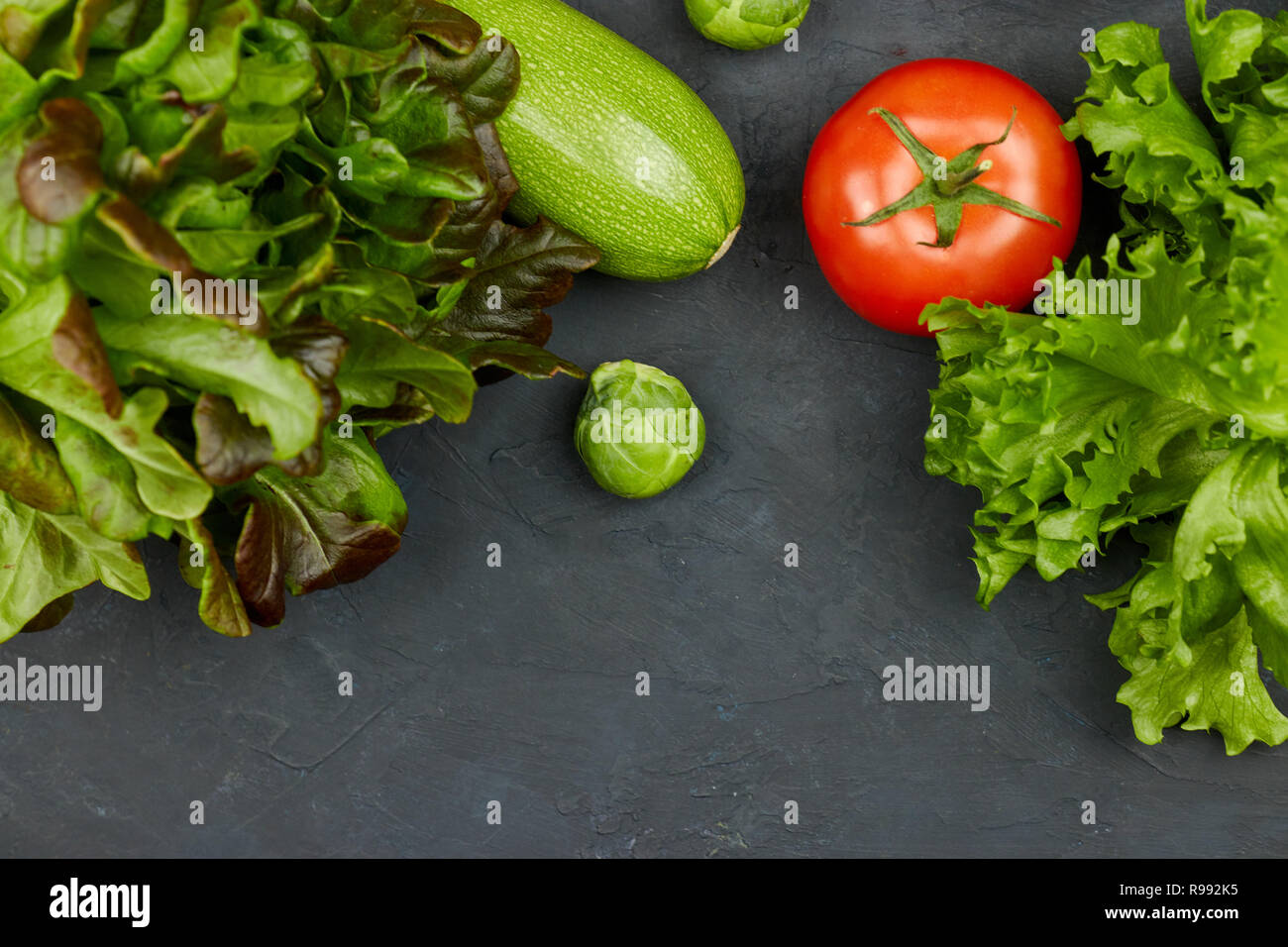 Gruppe von frischem Gemüse auf schwarzem Hintergrund. Es gibt Raum für Text in der Mitte. Copyspace. Stockfoto