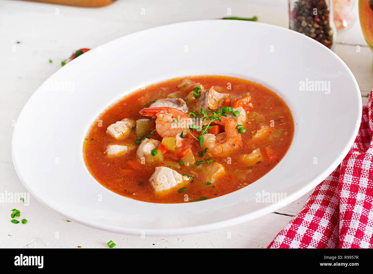 Brasilianische Lebensmittel: Moqueca capixaba von Fisch und Paprika in würziger Kokosnuss Sauce in eine Platte auf eine weiße Holztisch. Brasilianische fisch Eintopf. Stockfoto