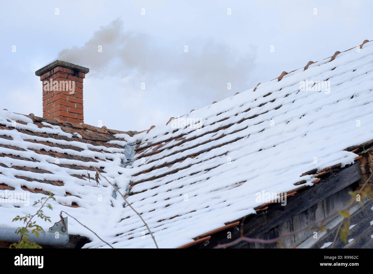 Rauchen Schornstein auf ein traditionelles Haus in einer ländlichen ungarischen Dorf im Schnee von einem frischen Schneesturm zala Ungarn Stockfoto