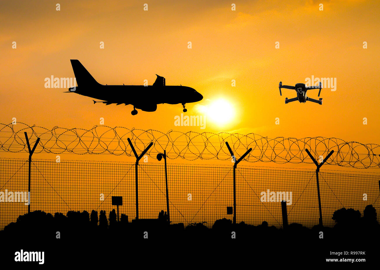 Unbemannten Drohne fliegen über sicherheitszaun am Flughafen während kommerzielle Flugzeug bereitet sich auf die Landung, die zu einer Kollision - digital Composite Stockfoto