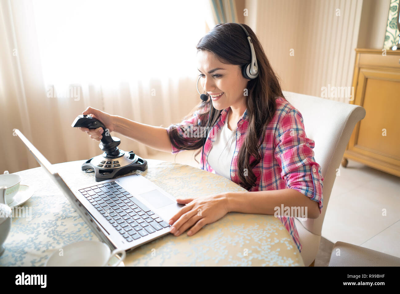 Schöne Mädchen spielt Video Spiel mit einem Retro Joystick Kopfhörer tragen. Gaming Joystick. Weibliche Gamer. Stockfoto