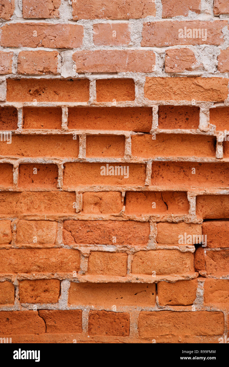 Hintergrund Bild des Alten erodiert Ziegelmauer mit einigen Ziegelsteinen teilweise verschwunden Stockfoto