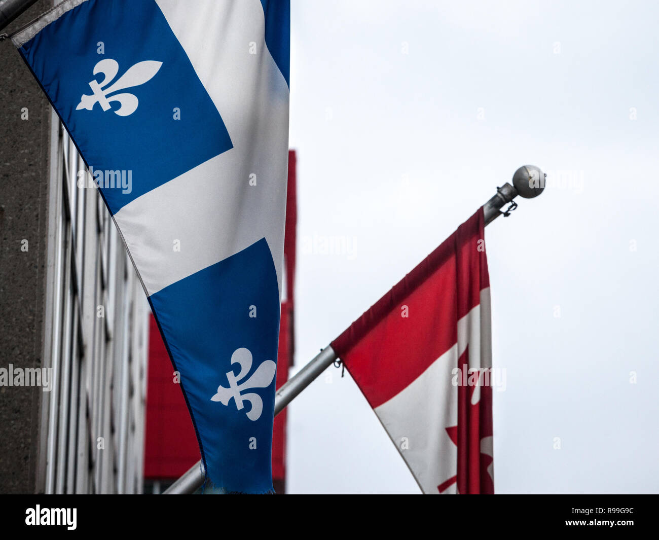 Quebec Flagge vor der offiziellen Flagge von Kanada in Montreal, die wichtigste Stadt von Quebec, die zweitgrößte Provinz Kanadas, Französisch sprechen. Stockfoto