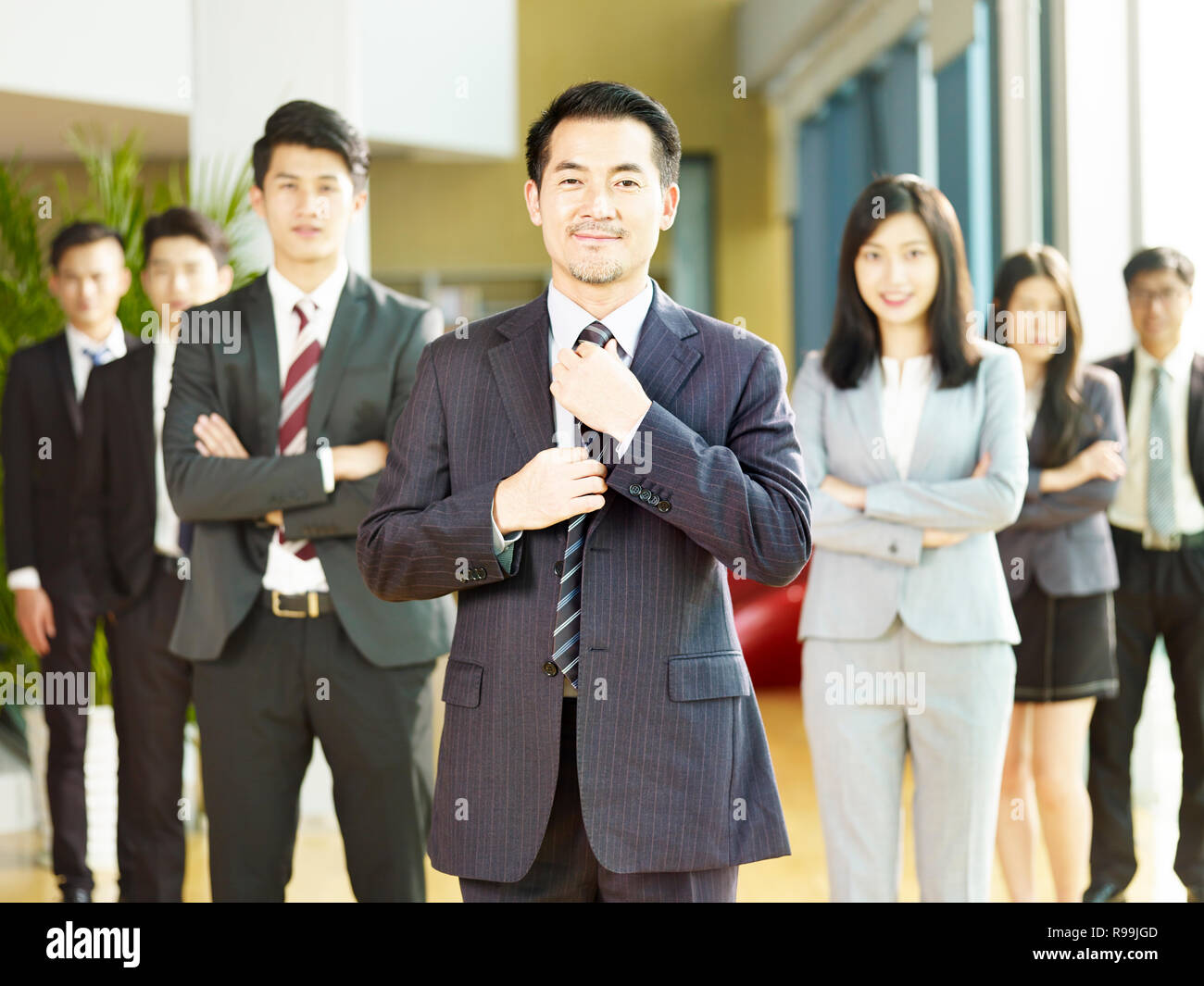 Porträt einer Mannschaft der Erfolgreichen asiatischen Geschäftsleuten und Geschäftsfrauen, an der Kamera schaut lächelnd. Stockfoto