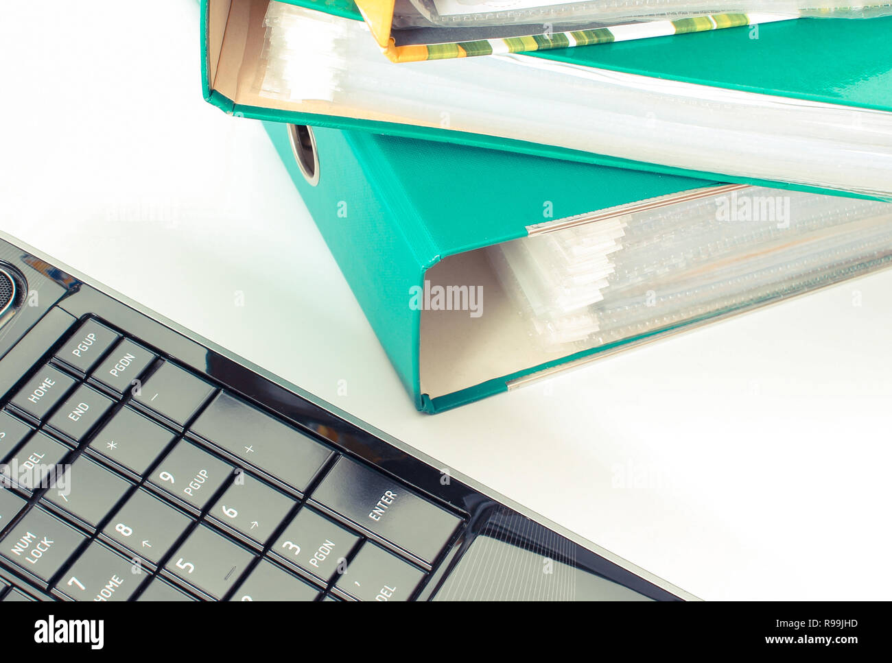 Laptop mit farbigen Ordner liegen auf weißem Schreibtisch Stockfoto