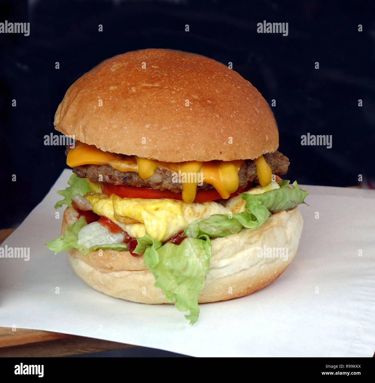 Ein lecker aussehenden Hamburger mit Salat, Tomaten, Käse und Ei Stockfoto