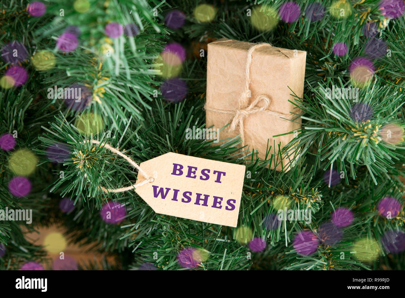 Geschenkboxen und Variable mit Inschrift "die besten Wünsche" auf Weihnachtsbaum Stockfoto