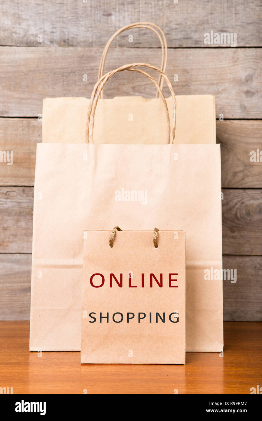 Tüten mit der Aufschrift "Online Shopping" auf hölzernen Hintergrund Stockfoto