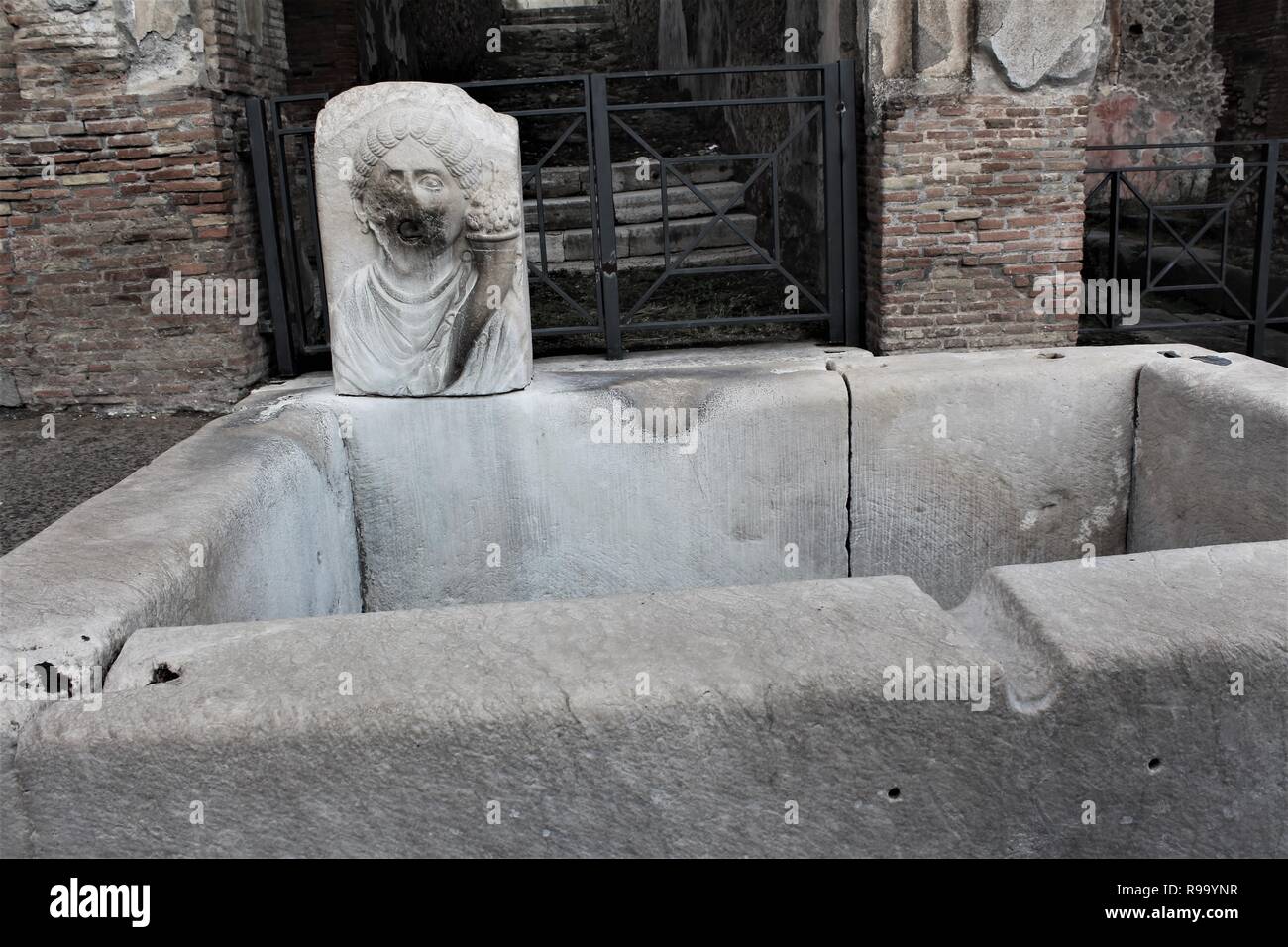 Die Überreste eines öffentlichen Trinkwasserbrunnen innerhalb der Ruinen der antiken römischen Stadt Pompeji, Italien. Stockfoto