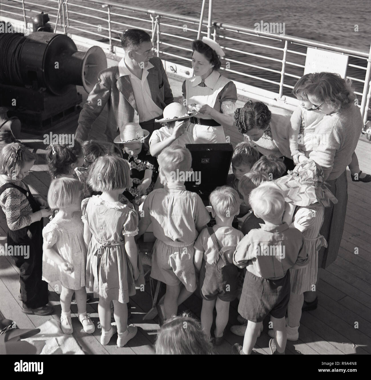 1950, historische, an Bord der Union - Schloss Dampfschiff "Kenia", "das Schiff Krankenschwester und Kind passsengers heraus stehen auf der Terrasse Musik hören von einem gramaphone Stockfoto