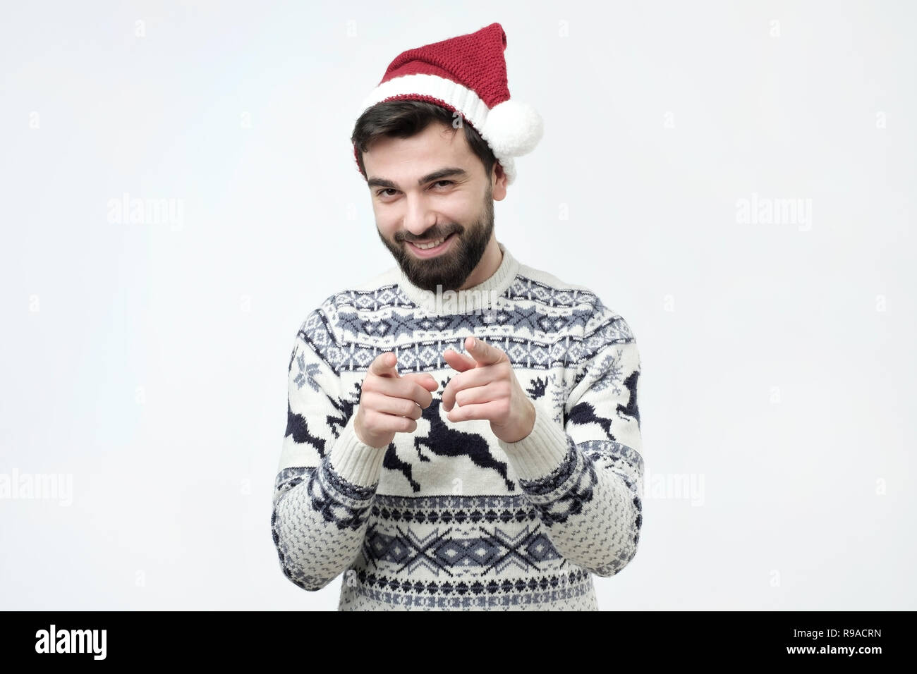 Aufgeregt, bärtigen Mann in rot weihnachten cap Pointing Finger an Kamera Stockfoto