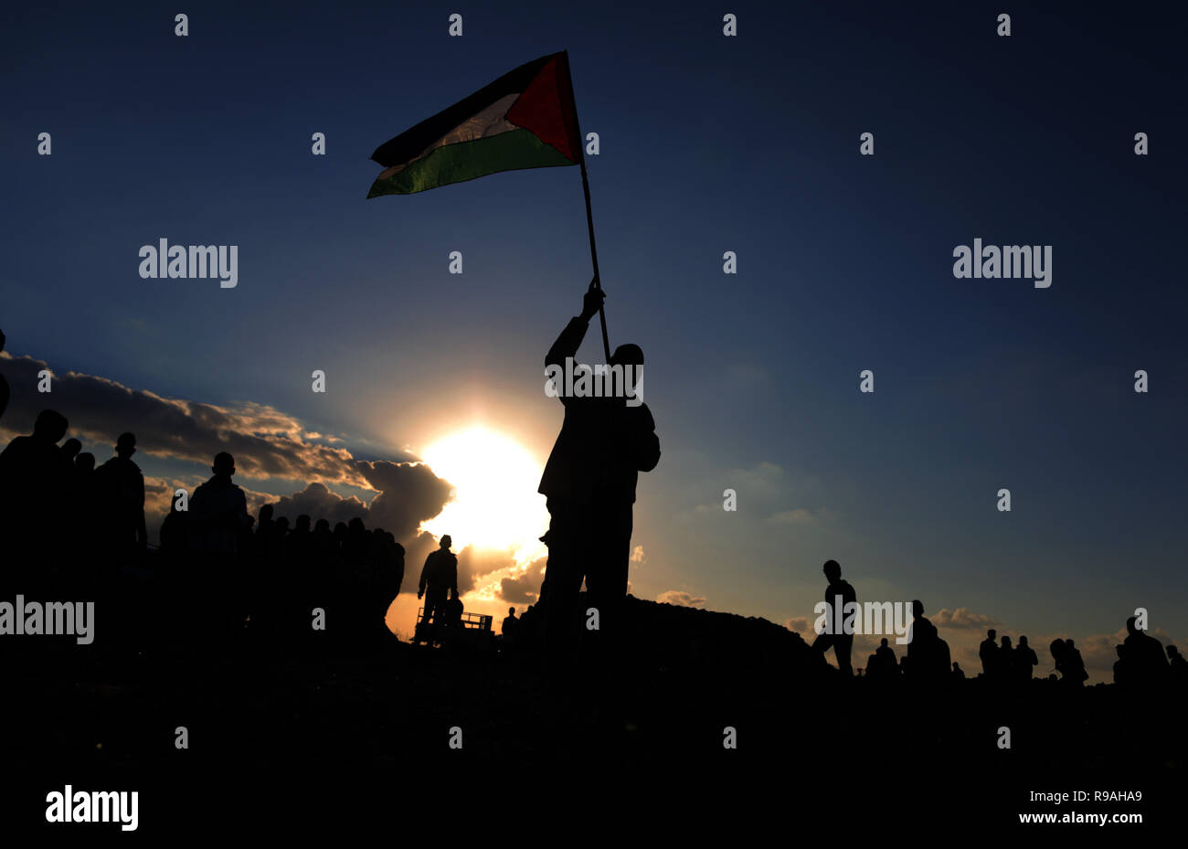 Gaza und die Palästinensischen Gebiete. 21. Dez 2018. Palästina - Silhouette eines Palästinensischen Mann gesehen, eine Flagge während der Proteste auf der Trennungsmauer zwischen Gaza und Israel. Credit: Yousef Masoud/SOPA Images/ZUMA Draht/Alamy leben Nachrichten Stockfoto