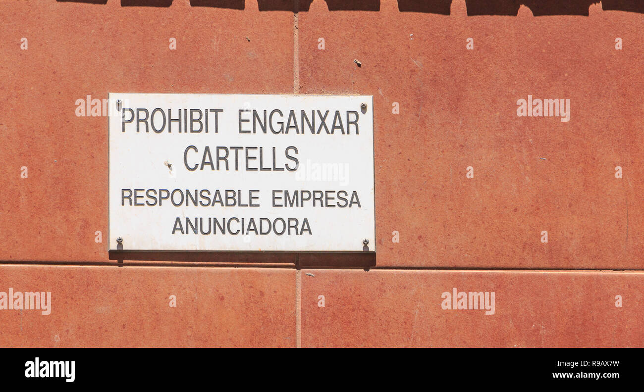 Barcelona, Spanien - 20. Juni 2017: Auf einer roten Wand ein Zeichen in Katalanisch - Selbstklebende Schilder verboten - Ankündigung Unternehmen verantwortlich. Stockfoto