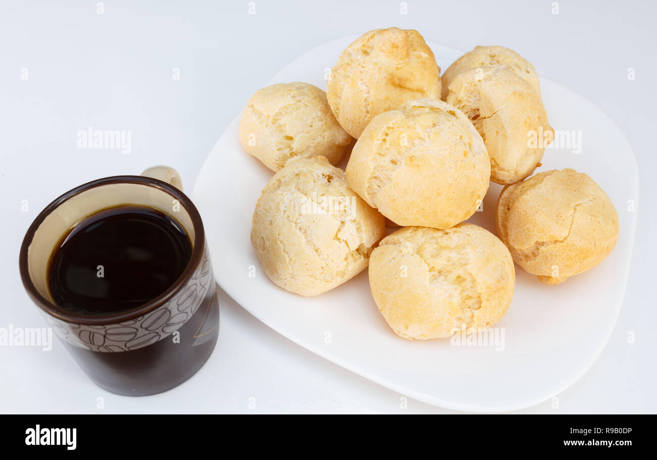 Brasilianisches Frühstück, Käse Brot (Pao De Queijo) auf Teller auf weißen Tisch mit Kaffee serviert. Stockfoto