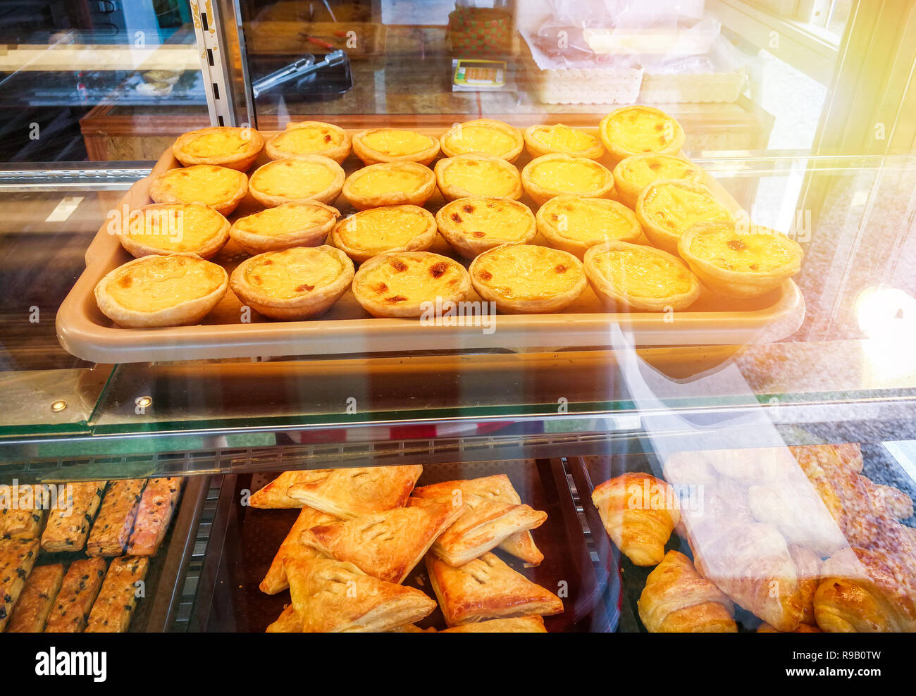 Ei tart auf Fach-/Nachtisch lecker Ei tart und Ananaskuchen im Schaufenster Glas in Kuchen und Backwaren Shop-eierstich tart Stockfoto