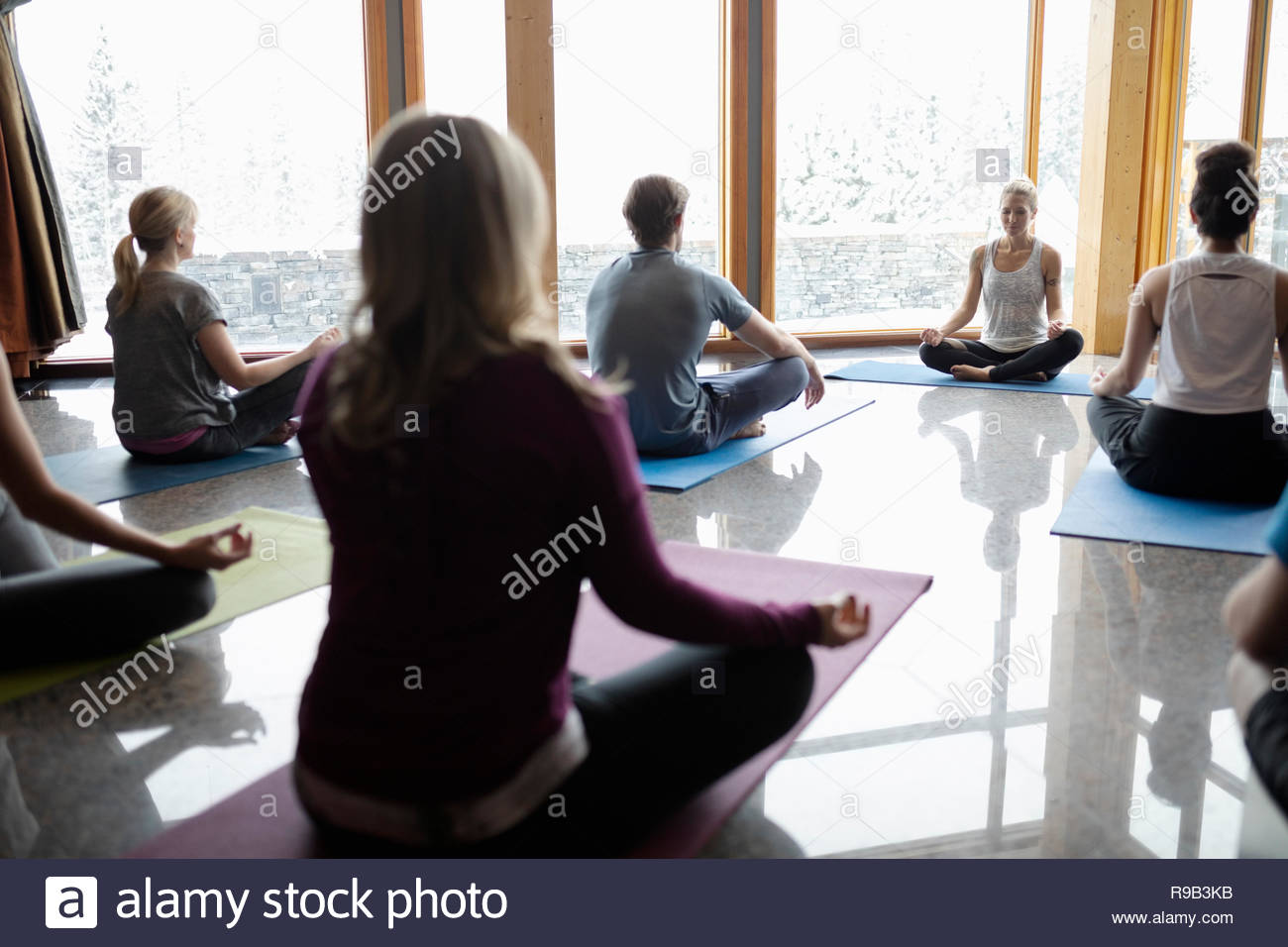 Kursleiter führenden Yoga Klasse im Lotussitz sitzen im Studio Stockfoto
