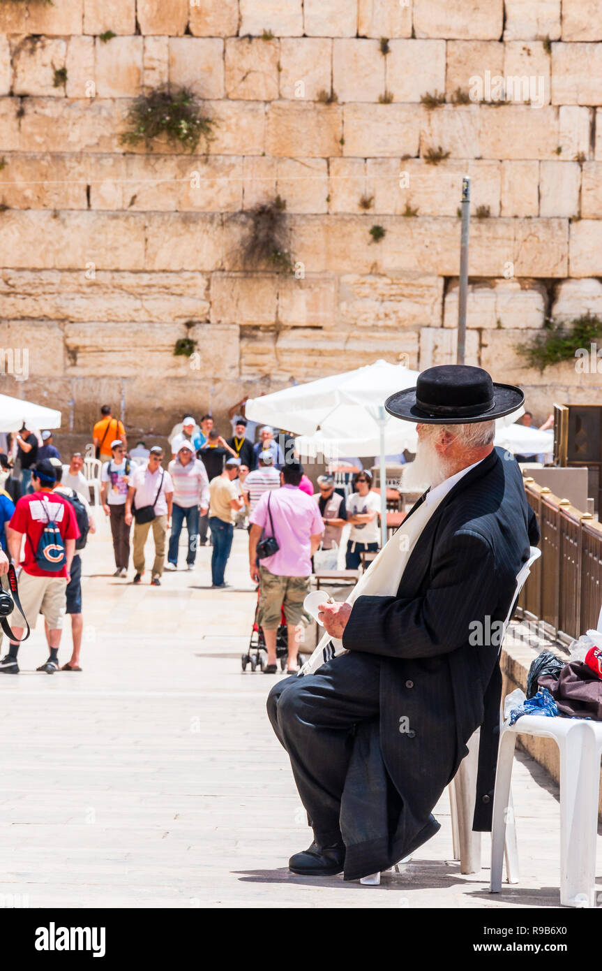 Jerusalem, Israel - 25. Mai 2012: jüdisch-orthodoxen im schwarzen Anzug und Hut in der Nähe Eingang alley sitzen an der westlichen Mauer. Menschen, Einheimische und Touristen w Stockfoto