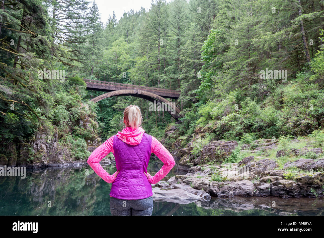 Weibliche Wanderer an der Brücke in der Natur suchen. Frau wandern im Freien, aktiven Lebensstil Konzept. Stockfoto