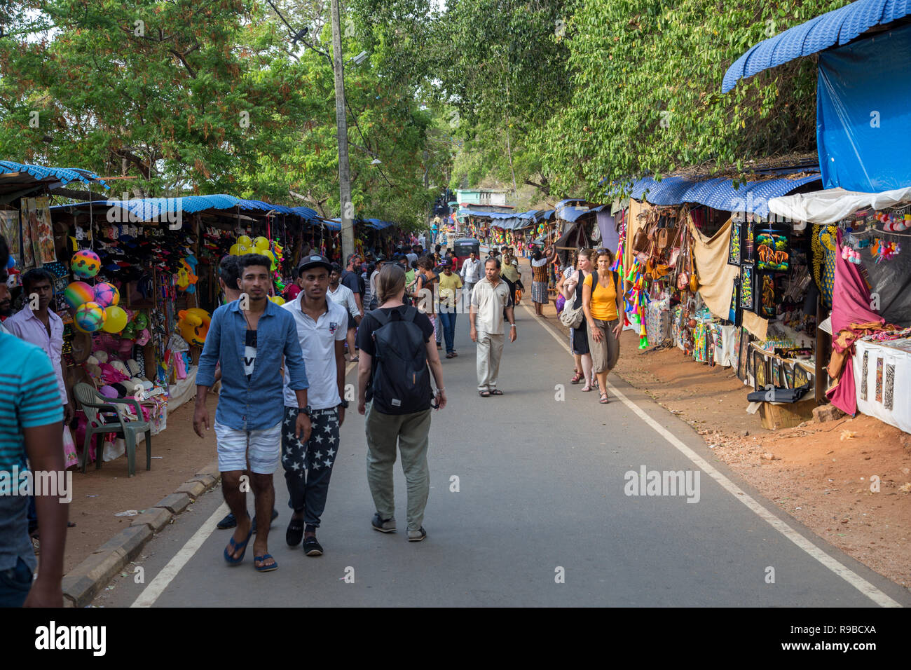 Trincomalee, Sri Lanka - 23. August 2018: Die Geschäfte entlang der Straße und die Leute zu Fuß in Richtung hinduistischer Tempel Koneswaram Stockfoto