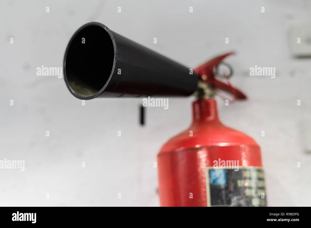 Rote Feuerlöscher auf weiße Wand im Hintergrund, gebrauchsfertig Stockfoto