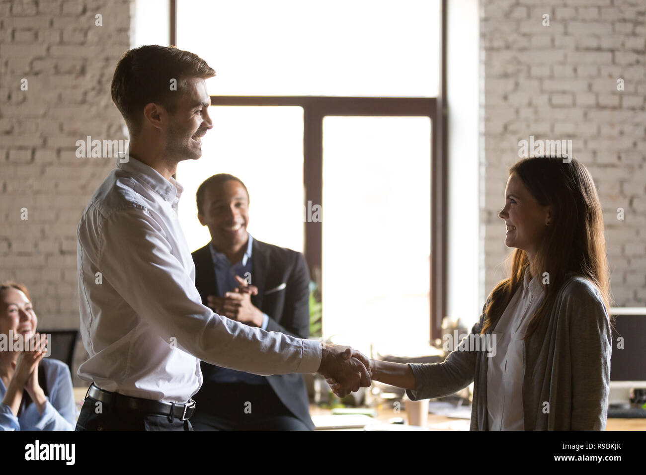 Männliche team leader Handshaking weiblichen aufgeregt Mitarbeiter congratulat Stockfoto