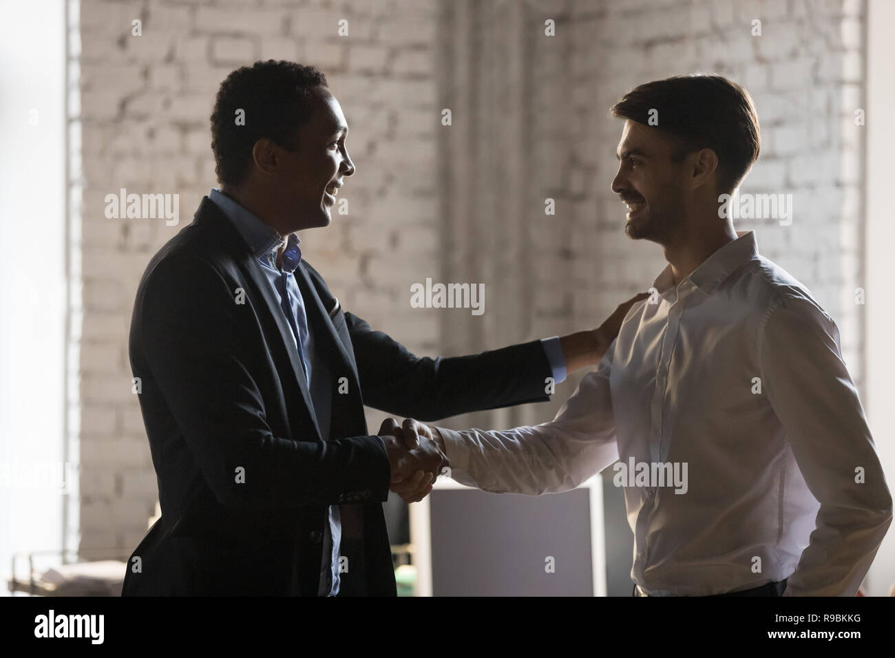 Afrikanische Executive Manager handshaking kaukasischen Mitarbeiter promoti Stockfoto