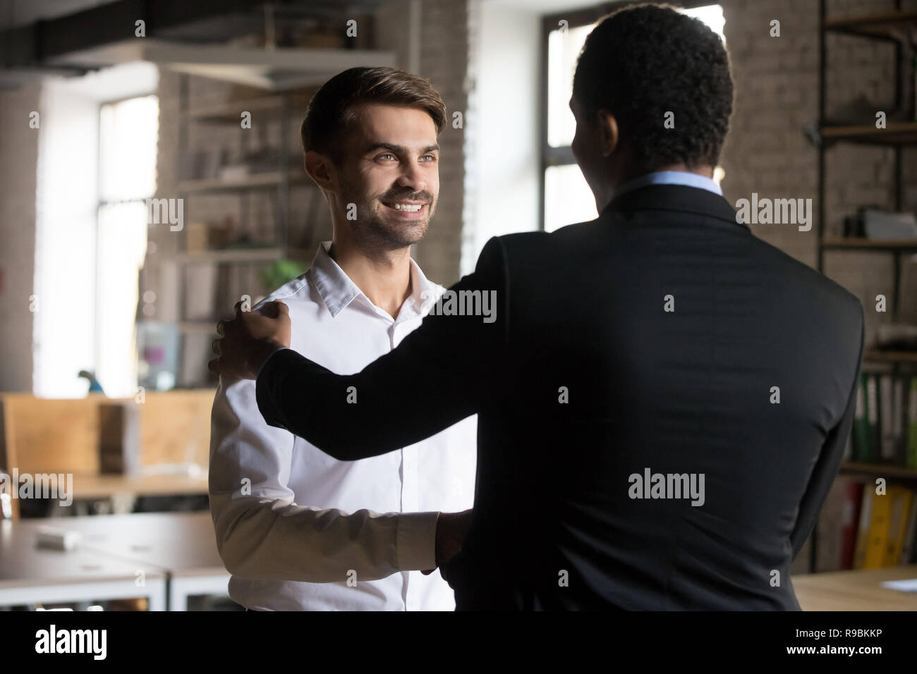 Happy kaukasischen Mitarbeiter immer belohnt zitternden Hand schwarz Stockfoto