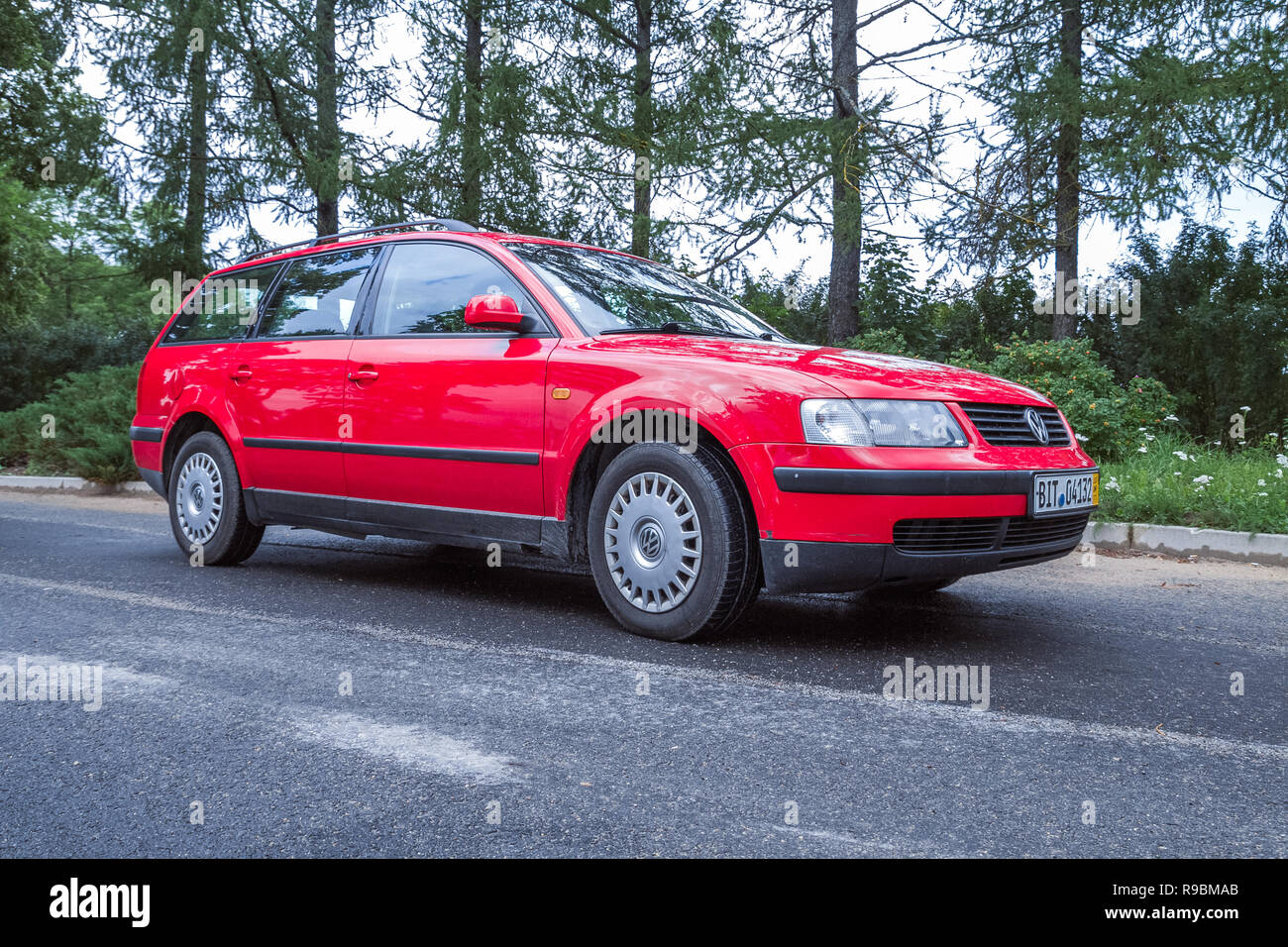 Stadt Cesis, Lettland. Red Wolksvagen Passat B5 Straße, Bäume einer Art und Weise. Reisen Foto 2012. Stockfoto