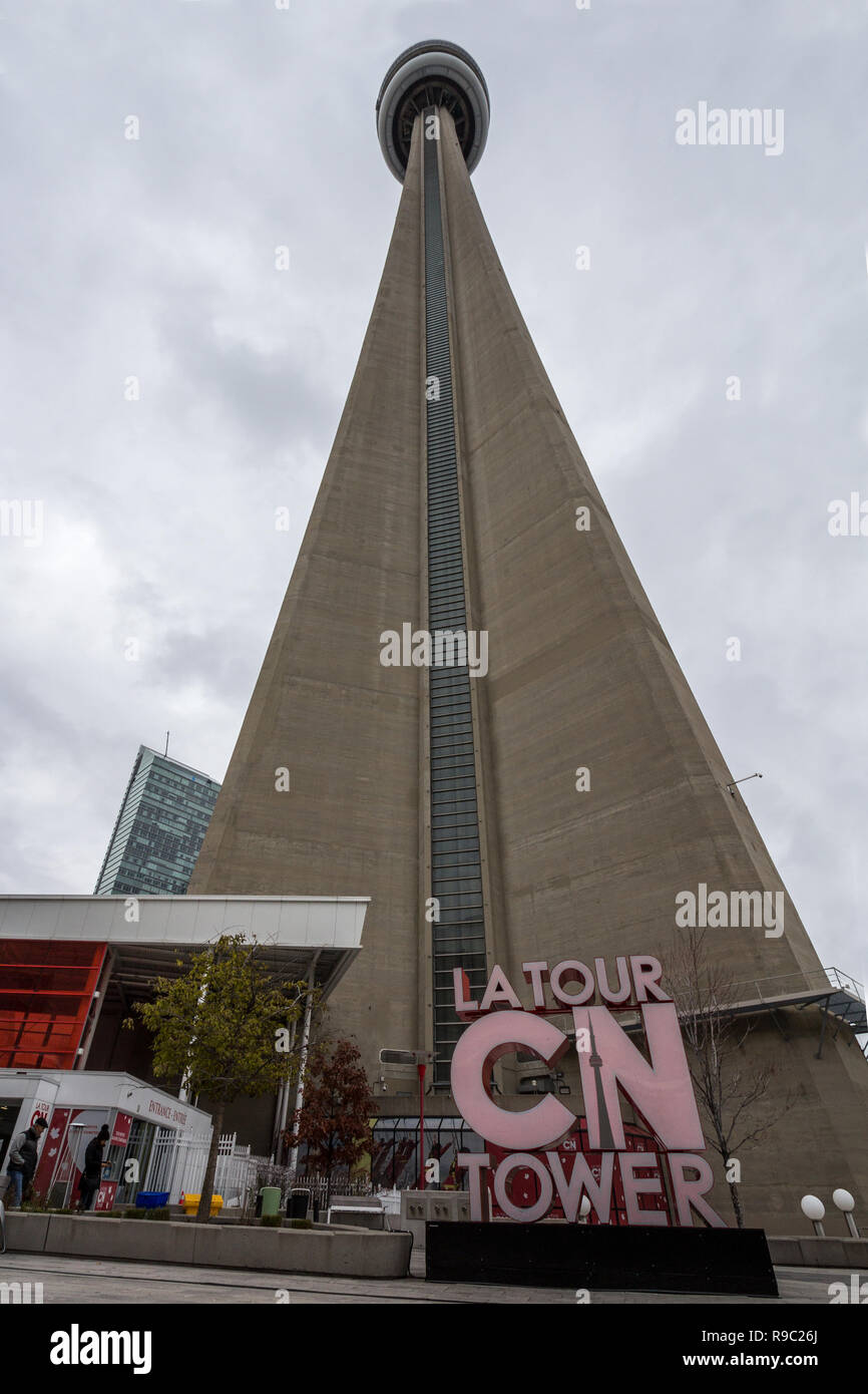 TORONTO, KANADA - 13 November, 2018: Blick auf die Canadian National Tower (CN Tower) von seiner Unterseite mit seinem Wahrzeichen Logo und dem Eingang. Es ist eine Stockfoto