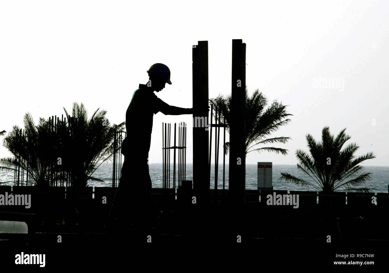 Dubai, Vereinigte Arabische Emirate, VAE - 14 JUN 2004: Arbeitnehmer Silhouette am späten Nachmittag bei der Verlegung ein Gebäude Stiftung in der Dubai Marina, die eine Nabe wurde von Hunderten von größeren Bauvorhaben, während der Hochkonjunktur. Stockfoto