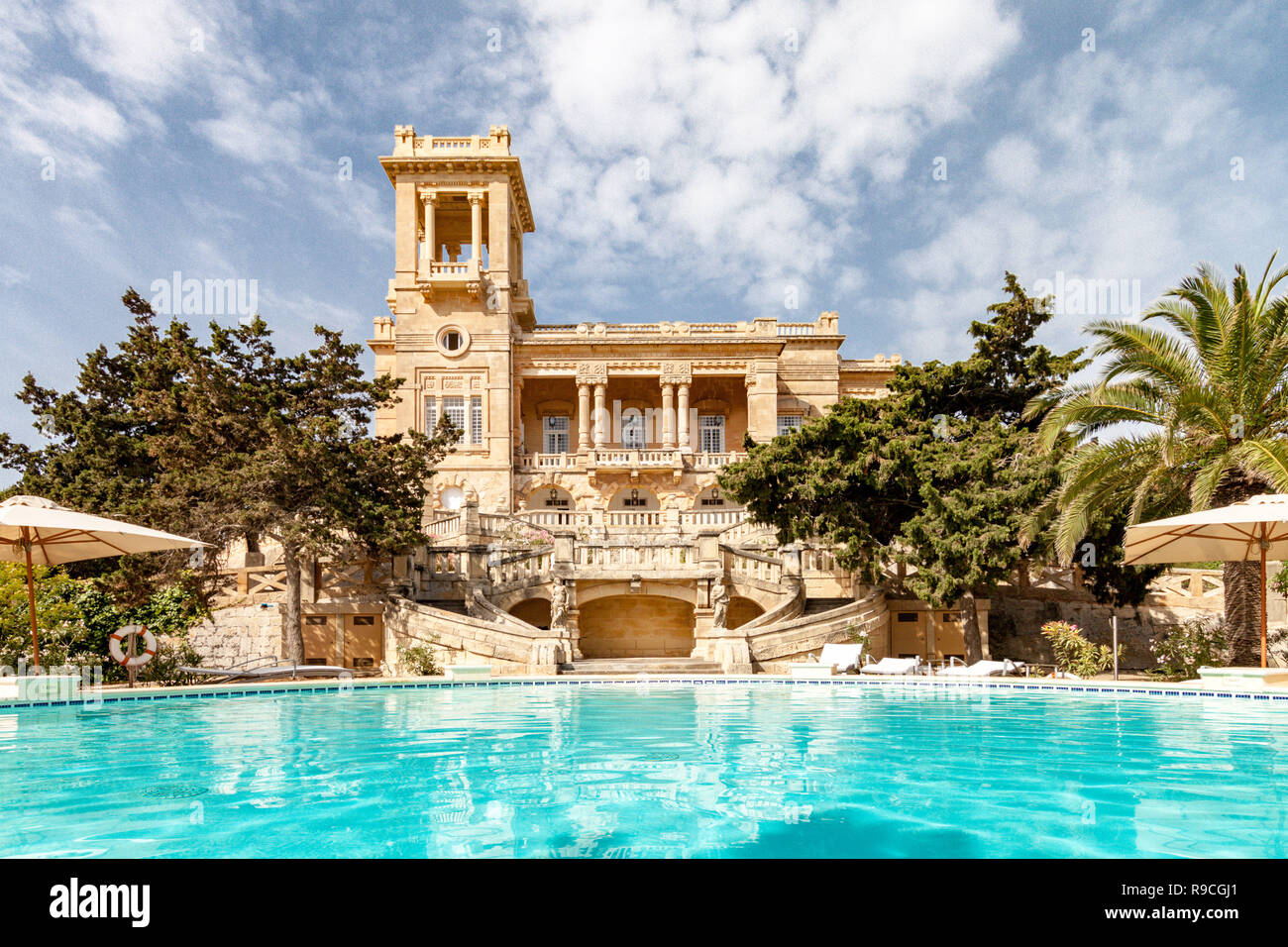 St. Julian's, Malta. 1920 Jugendstilvilla Villa Rosa im ​Park in St. Julian's Stadt erbaut vom Architekten Andrea Vassallo, Malta, reflektiert in einem azurblauen Pool. Stockfoto
