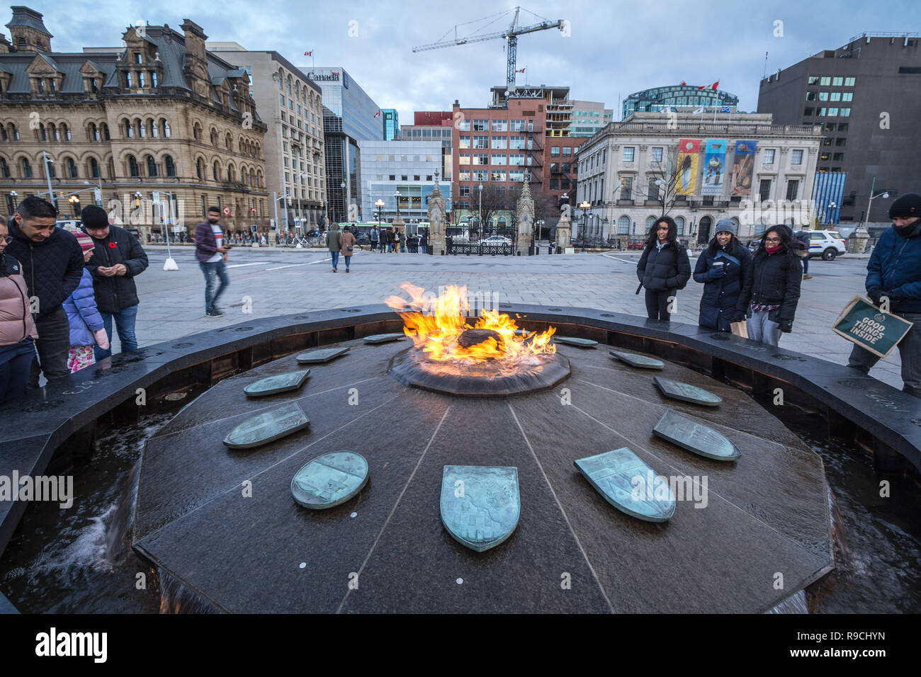 OTTAWA, Kanada - 10. NOVEMBER 2018: Centennial Flam, vor dem Kanadischen Parlament, mit Touristen Erwärmung. Der Brunnen und sein Feuer zu gedenken. Stockfoto