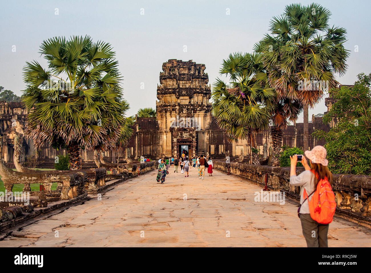 Touristen an der Tempelanlage Angkor Wat gehen auf einem Sandstein Straße, die zu einem großen, steinernen Tor in Siem Reap, Kambodscha. Stockfoto