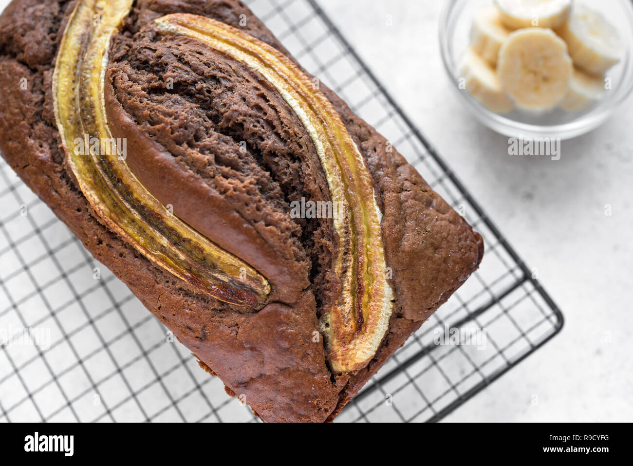 Hausgemachte Schokolade Banane Brot auf weißem Hintergrund, aus der Nähe. Gesunde Banane Brot oder Kuchen mit dunkler Schokolade zum Frühstück, Ansicht von oben. Stockfoto