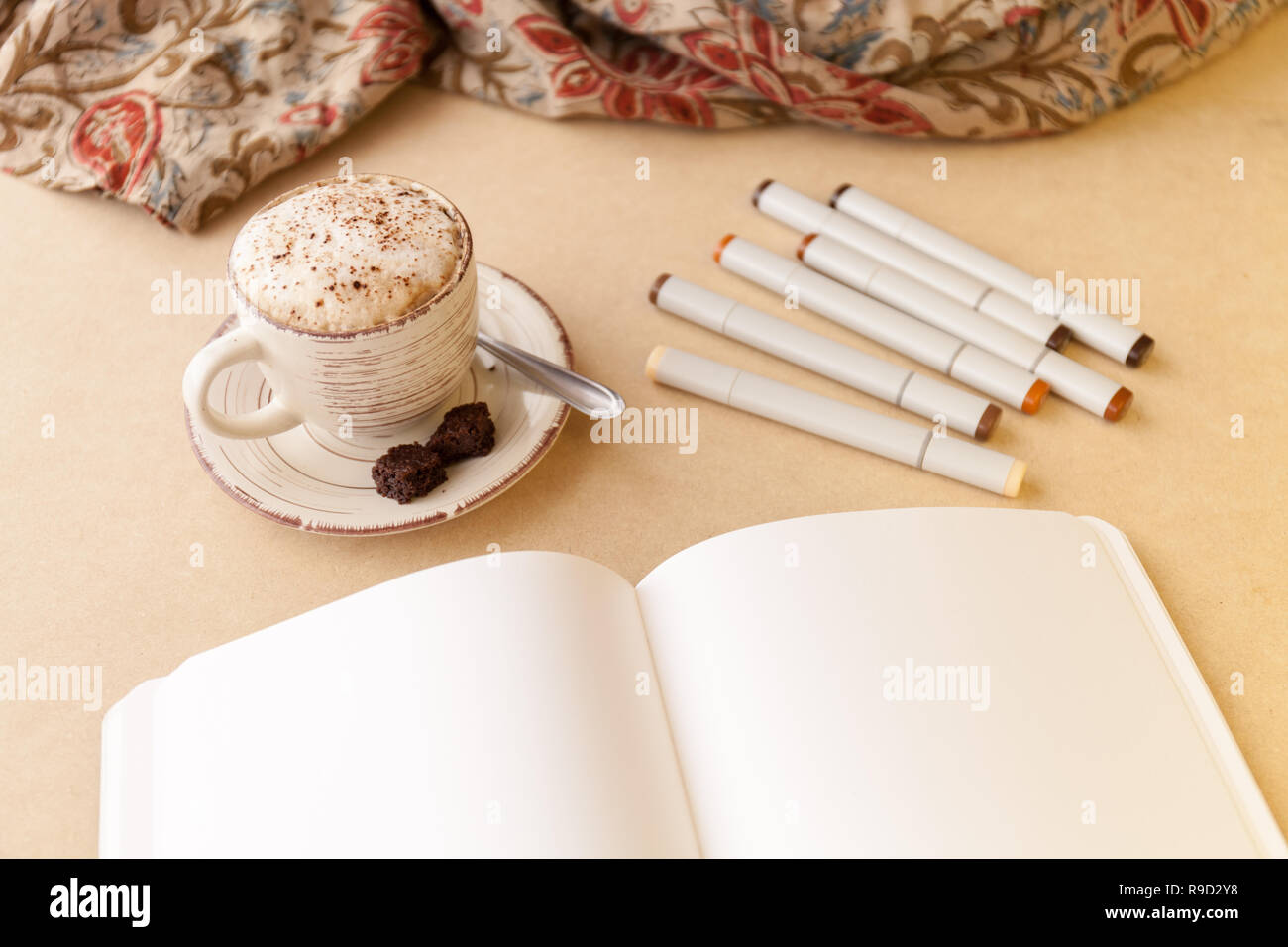 Öffnen Skizzenbuch, Bündel von künstlerischen Marker und Latte auf einen Tisch. Querformat Stockfoto