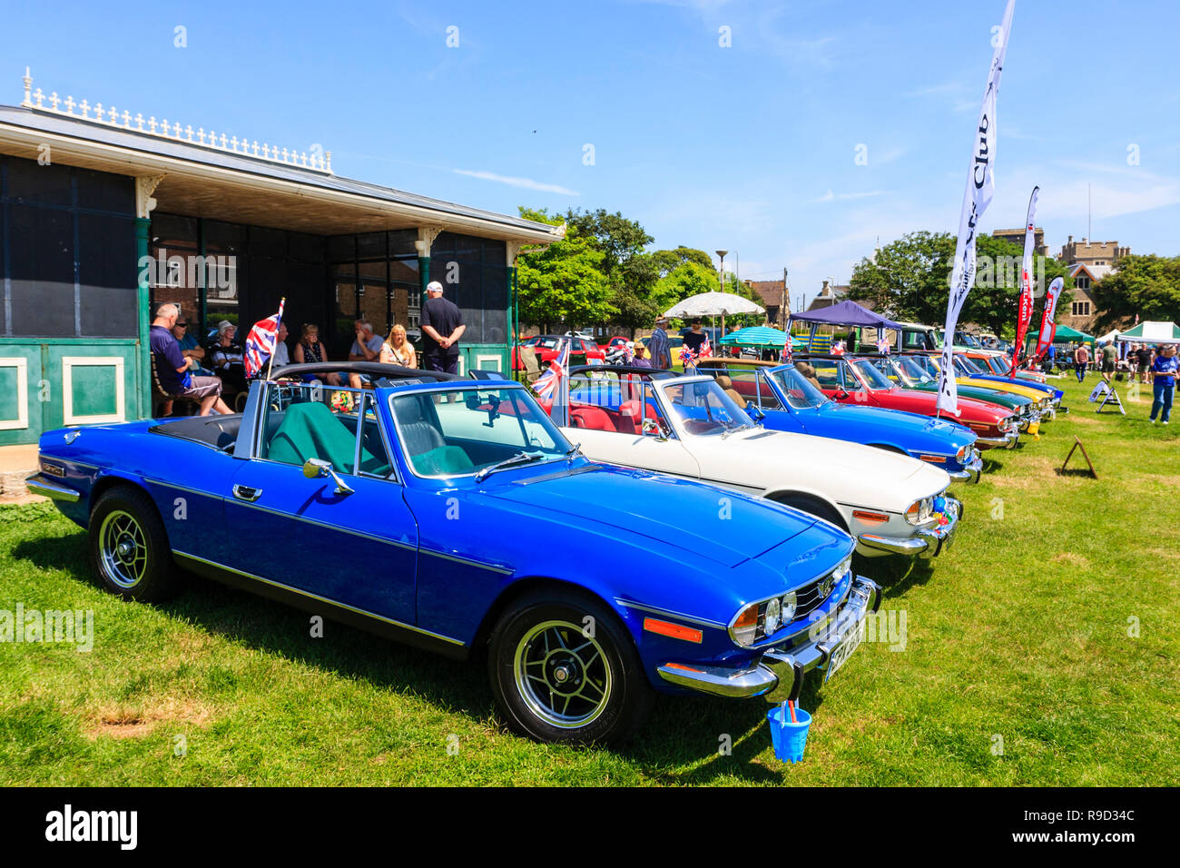 Schaufel und Spaten Classic Car Show auf Ramsgate Strandpromenade. Reihe von sieben vintage Triumph Bühne Autos, in verschiedenen Farben. Strahlender Sonnenschein, blauer Himmel. Stockfoto
