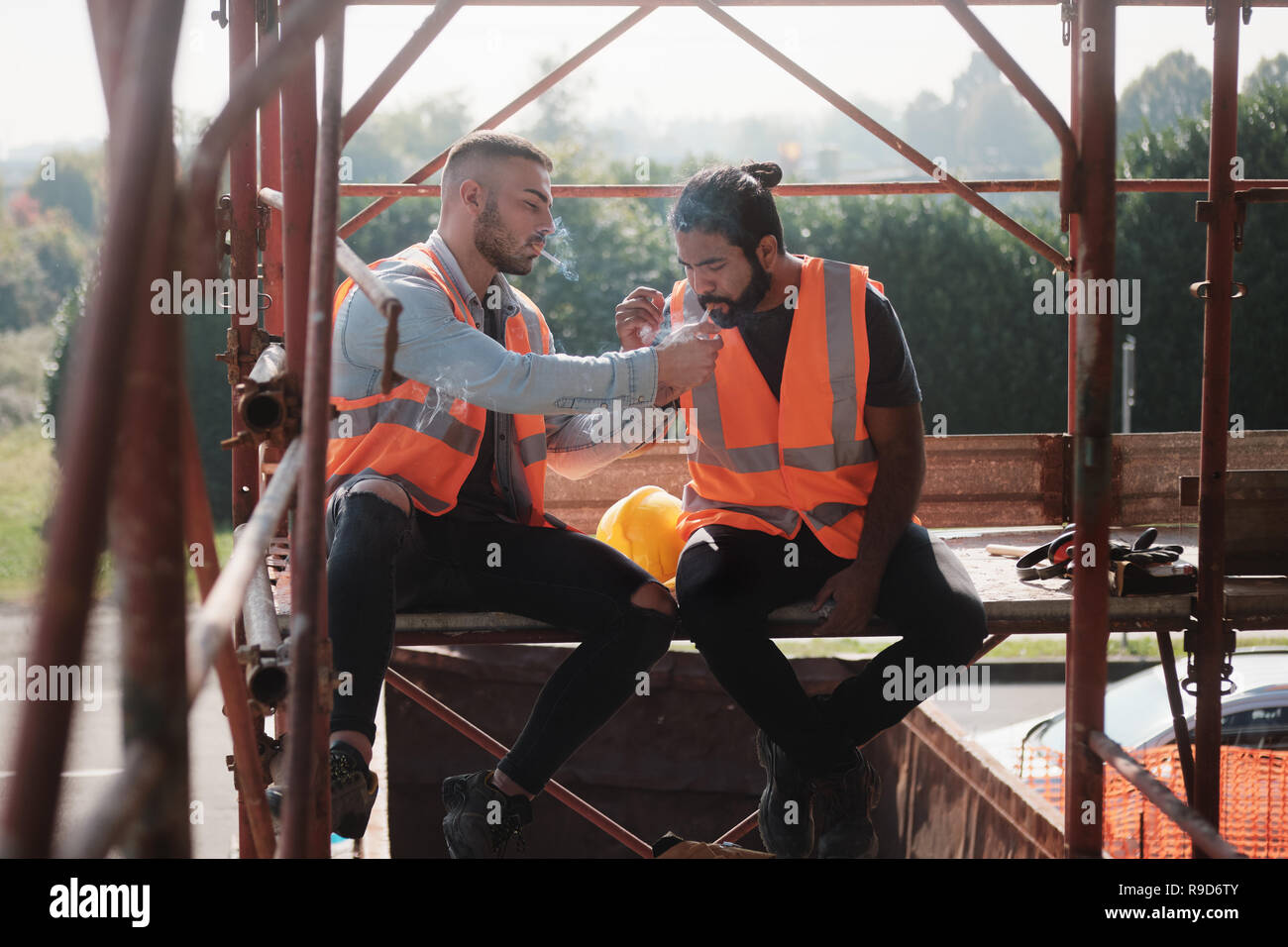 Bauarbeiter Rauchen Zigarette und Gespräch in der Pause Stockfoto