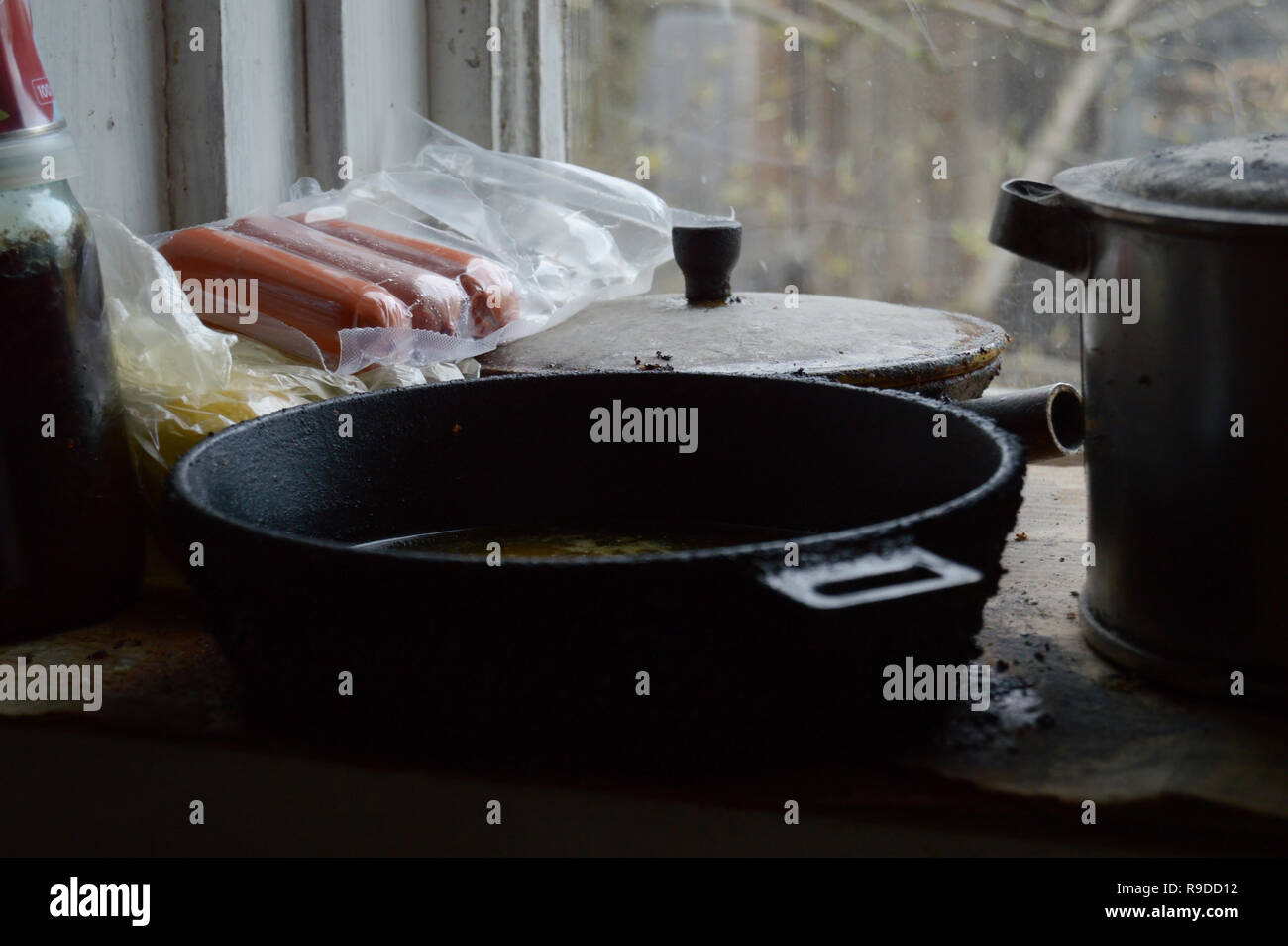 Kovrov, Russland. 2. Mai 2016. Essen (Paket öffnen von Würstchen) und alten schmutziges Geschirr auf dem Fensterbrett in der Küche des 1-stöckigen alten Holzhaus Stockfoto
