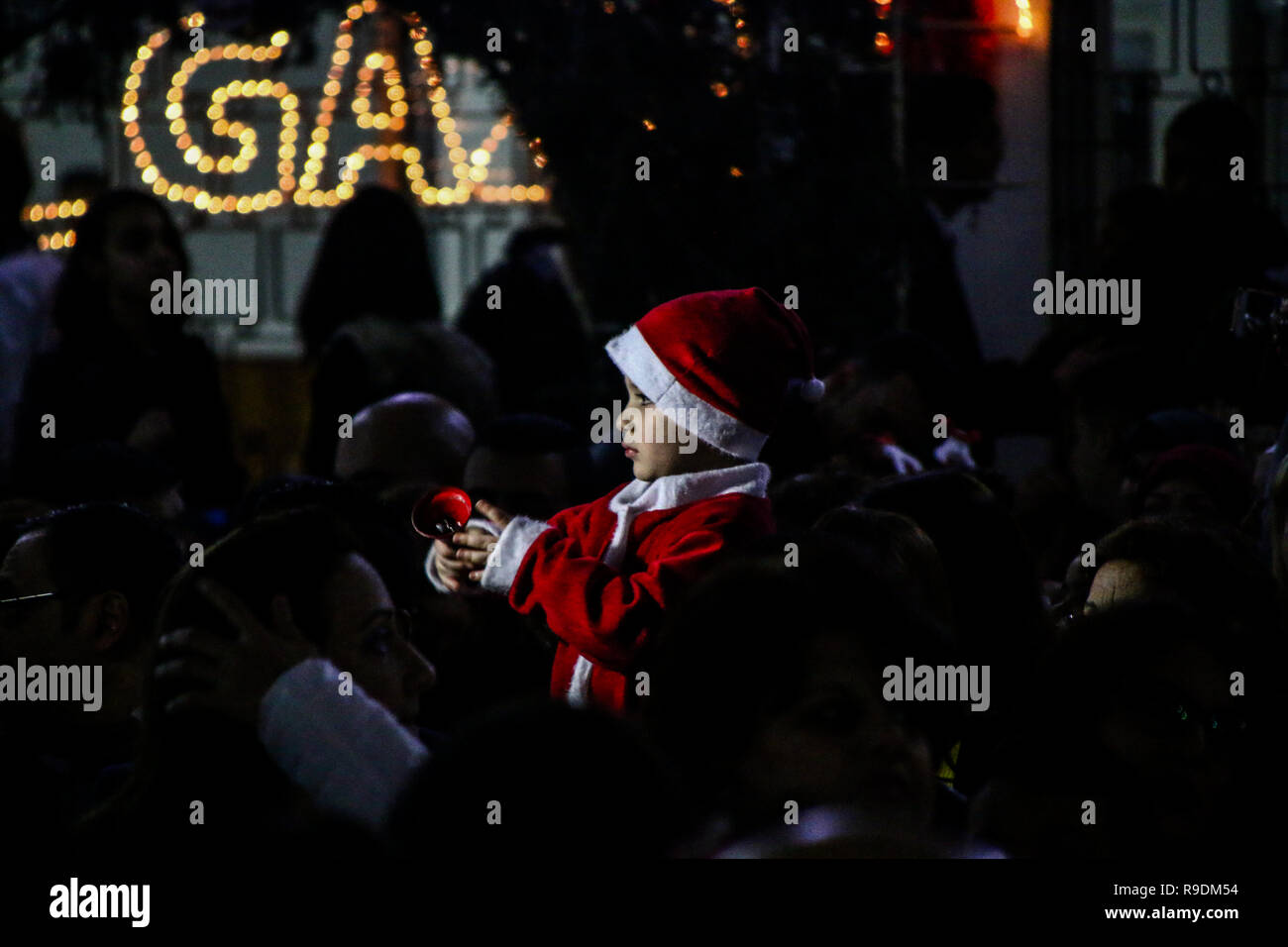 Gaza, Palästina. 22. Dez 2018. Das YMCA im Gazastreifen den Weihnachtsbaum Zeremonie in seinen Platz in Gaza Stadt organisieren am Abend des 22. Dezember 2018. Eine palästinensische Folklore tanzen und den Segen eines griechisch-orthodoxen Patriarchen begleitet die Zeremonie in der bis zum Heiligabend. Christliche und muslimische Palästinenser converged auf dem Platz in Gaza zu feiern und den Dekorationen und andere Traditionen der Jahreszeit, wie Fotos der Kinder mit Santa Claus und Nächstenliebe Sammlungen für die Bedürftigsten zu genießen. Credit: ZUMA Press, Inc./Alamy leben Nachrichten Stockfoto