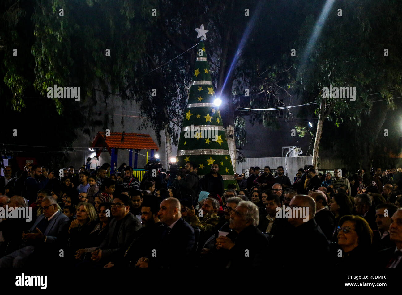 Gaza, Palästina. 22. Dez 2018. Das YMCA im Gazastreifen den Weihnachtsbaum Zeremonie in seinen Platz in Gaza Stadt organisieren am Abend des 22. Dezember 2018. Eine palästinensische Folklore tanzen und den Segen eines griechisch-orthodoxen Patriarchen begleitet die Zeremonie in der bis zum Heiligabend. Christliche und muslimische Palästinenser converged auf dem Platz in Gaza zu feiern und den Dekorationen und andere Traditionen der Jahreszeit, wie Fotos der Kinder mit Santa Claus und Nächstenliebe Sammlungen für die Bedürftigsten zu genießen. Credit: ZUMA Press, Inc./Alamy leben Nachrichten Stockfoto